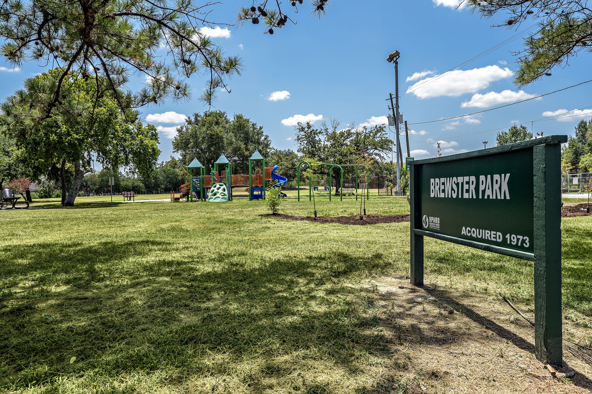 Sign at Brewster Park with play areas in the background